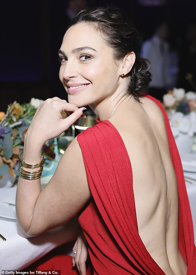 Gal Gadot turns heads in a slinky scarlet backless gown as she joins an A-list crowd at Tiffany & Co party