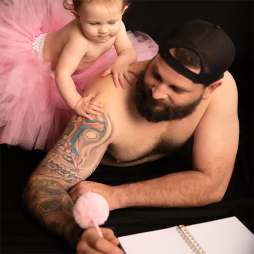 Dad and little daughter together wearing princess dresses for a photo