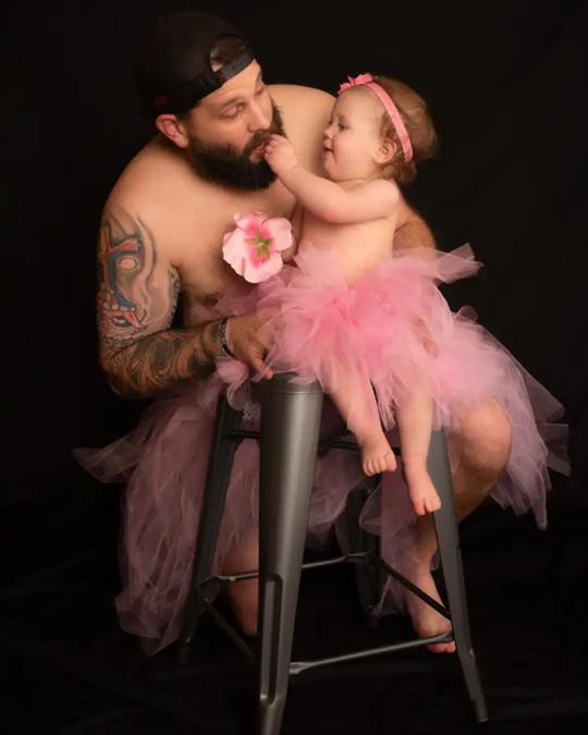 Dad and little daughter together wearing princess dresses for a photo